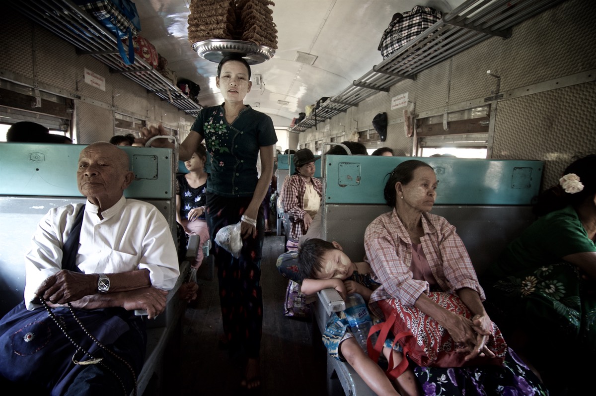 Vernod balancing food on her head and passengers in a train, Myanmar (Burma), Asia